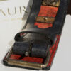 Black and red leather collar with rich brass ornamentation